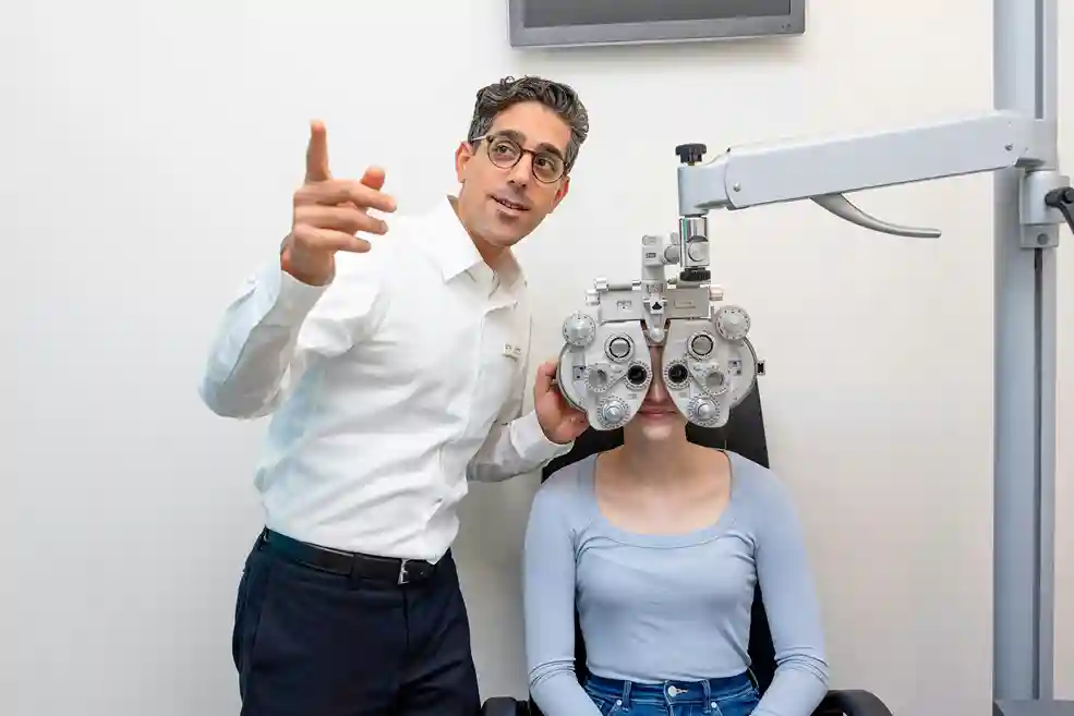 A male optometrist testing a lady's eyes